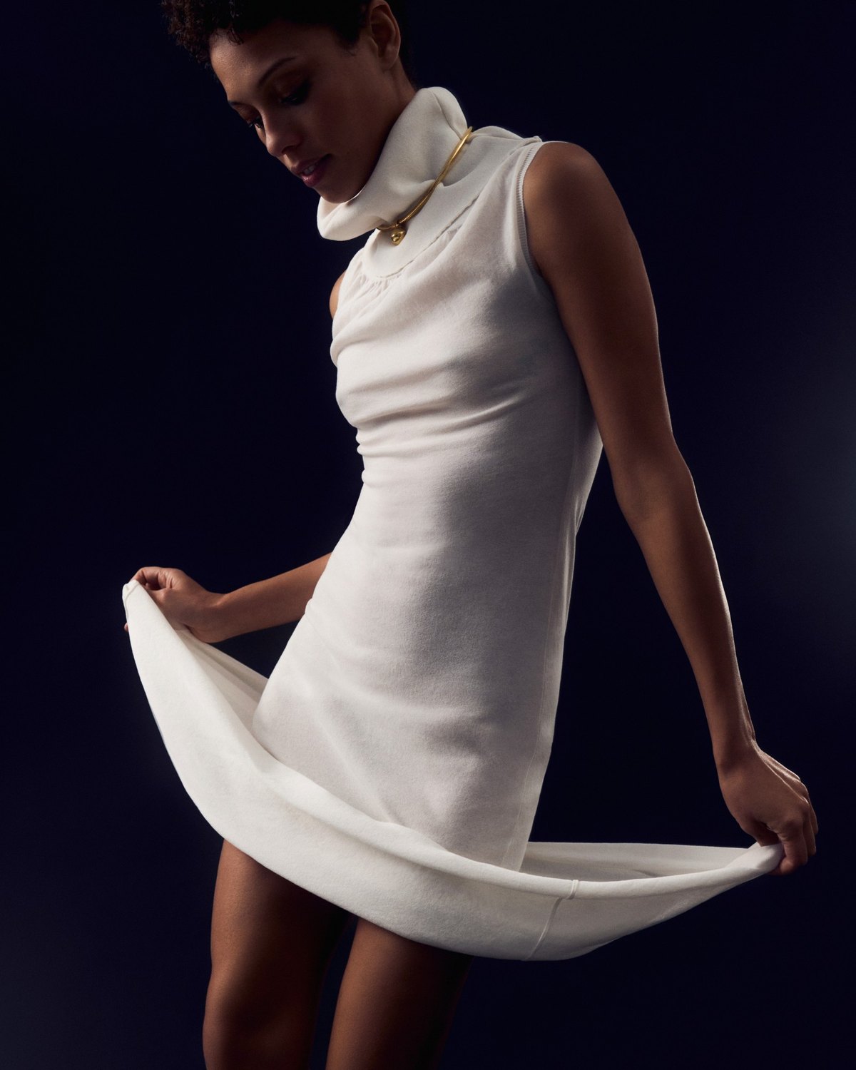 Faith Love Hope editorial: white roll-neck dress against a dark backdrop