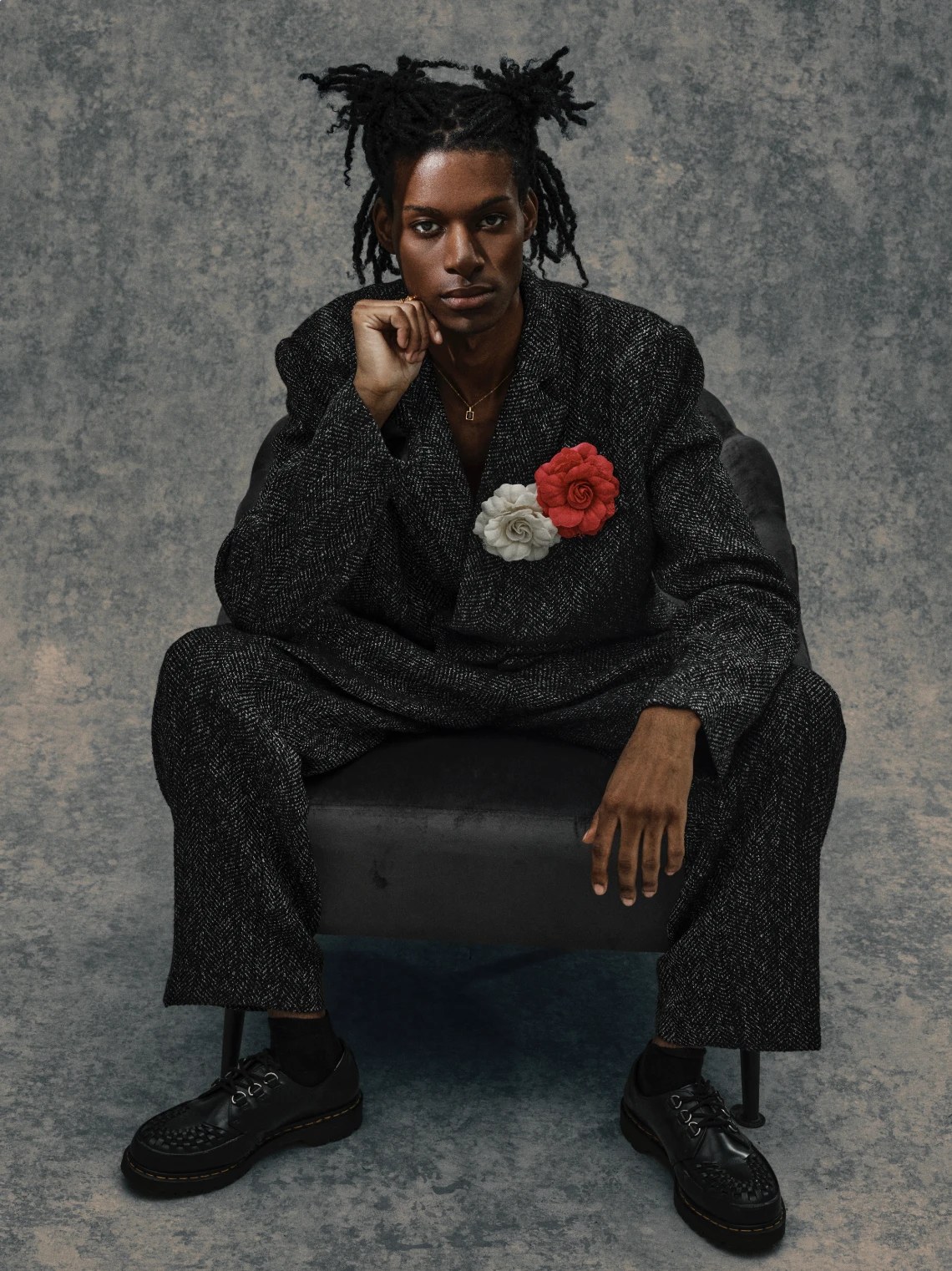 Gordon Stabbins portrait: tweed suit with flower brooches, seated in an armchair